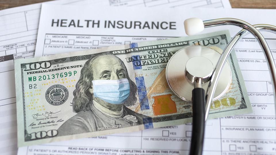 Stack of insurance papers, $100 bill with a masked Ben Franklin and a stethoscope.